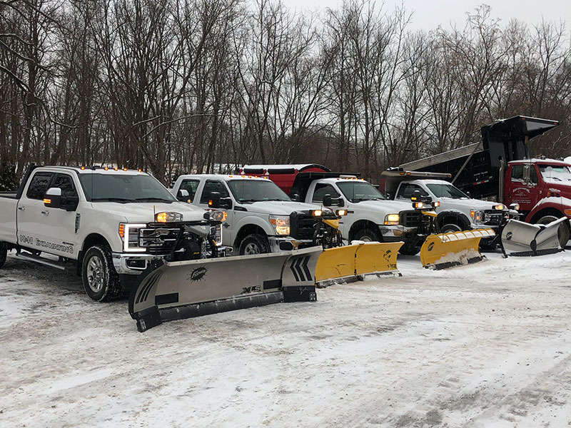Row of 4 trucks with snowplows